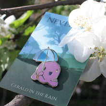 Hard enamel pin of an octopus holding an umbrella nestled within apple blossoms on a tree
